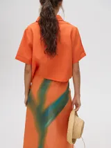 Falda midi marrón con estampado floral en tonos lila, abertura lateral y tiras ajustables.