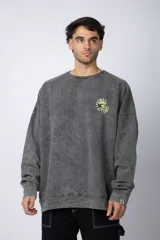 Buzo gris con efecto lavado, cuello redondo, corte oversize y estampado pequeño en el pecho.
