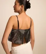 Blusa cropped metalizada con breteles finos ajustables y abertura en la espalda.