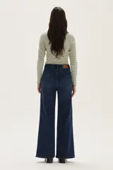 Jean de mezclilla azul oscuro, tiro alto, corte recto y ancho en la pierna.