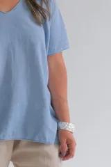 Remera celeste de corte amplio, con cuello en V y mangas cortas.