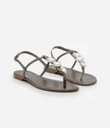 Sandalia plana dorada con tiras finas y aplicación de pedrería.