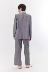 Blazer de lino color crudo con rayas verticales finas en color dorado, de corte recto, con solapas y cierre con un botón.