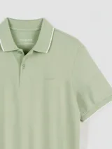 Remera tipo polo color beige, de corte clásico, con cuello y puños acanalados en contraste marrón oscuro.