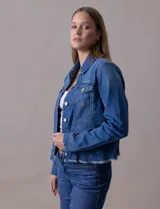 Campera de jean azul de la marca Baccini, con cuello solapa, abertura central con botones metálicos, bolsillos delanteros y ruedo desflecado.