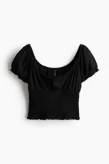 Blusa negra con escote cuadrado, mangas cortas abullonadas con elástico en hombros y puños, cintura fruncida y abertura con cordón para ajustar en el delantero.