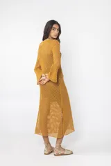 Vestido largo de tejido de punto abierto (red) color crudo, de manga larga y escote redondo.