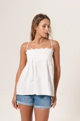 Blusa blanca con tirantes finos y escote recto con detalle de encaje.