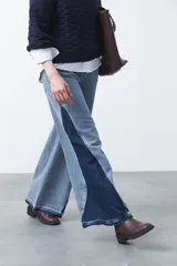 Jean de calce ultra wide confeccionado en denim de algodón color negro. Presenta una silueta amplia desde la cadera y un panel lateral en contraste que estiliza la pierna.