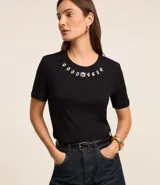 Blusa roja de mangas cortas confeccionada en viscosa con cuello redondo con apliques brillantes en formas florales.
