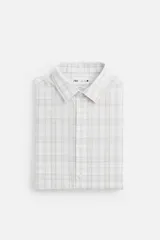 Camisa de vestir slim fit de algodón, color blanco con diseño de cuadros en tonos grises y beige. Tiene cuello italiano, mangas largas con puños abotonados y cierre frontal con botones.