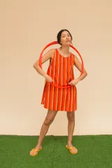 Vestido corto a rayas verticales en tonos marrón, negro y naranja. De corte recto, sin mangas y con cuello redondo. Confeccionado en algodón.