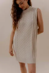 Vestido corto tejido color beige, sin mangas y con cuello redondo.