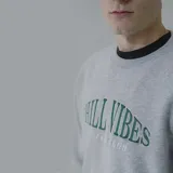 Buzo gris con estampa frontal de letras en verde.