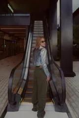 Pantalón ancho verde oliva con bolsillos cargo y aplique de cinta con rayas blancas en los laterales.