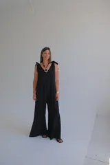 Mono largo negro con escote en V y tirantes anchos con lazos en los hombros.