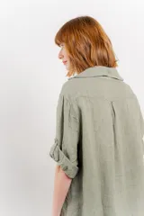 Camisa color beige de lino, con corte recto y calce suelto, cuello camisero, botones en el frente y mangas cortas con presilla y botón.