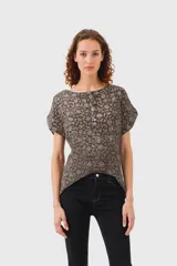 Blusa marrón con estampado floral en tonos beige, corte recto, cuello redondo y mangas cortas.