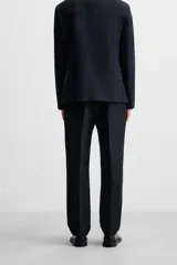Pantalón de vestir azul marino, de corte recto, con pinzas frontales, bolsillos laterales y traseros con doble vivo y botón.
