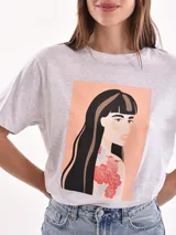 Remera color amarillo claro con estampado de limones, hojas y flores en tonos verdes y grises.