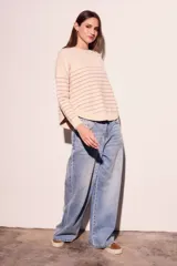 Sweater color crema con rayas horizontales finas color marrón claro, de corte holgado y mangas largas.