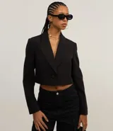 Blazer negro cropped de corte slim, con escote en V, solapas y un único botón frontal.