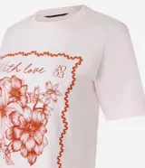 Remera de algodón color rosa con cuello redondo y mangas cortas. Estampa frontal con moldura, flores y texto "With love from Barcelona".