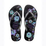 Sandalias Havaianas Slim Organic negras con estampado floral en tonos celeste y lila, y tiras plateadas.