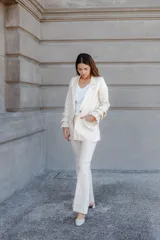 Pantalón de lino color beige, de tiro alto y pierna levemente acampanada, con pinzas delanteras.