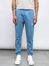 Pantalón de jogging gris de felpa sin friza, con cintura elástica ajustable con cordón y logo de Umbro estampado en blanco en el muslo izquierdo.