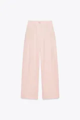 Pantalón de vestir color rosa pálido, de tiro alto, con pinzas delanteras, bolsillos laterales, pierna ancha y cierre frontal con cremallera y botón.