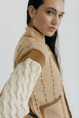 Chaqueta tejida en lana merino y lambswool color negro, con detalles bordados en beige y marrón.