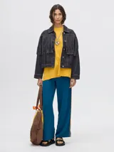 Campera de jean negra con flecos en la parte delantera y cuello camisero.