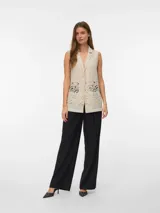 Top sin mangas color beige con cuello en V y detalle de encaje en la parte inferior.
