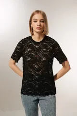 Top negro de encaje con mangas cortas, cuello redondo y corte holgado.