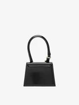 Bolso estructurado de piel lisa color borgoña, con asa reforzada de hebilla metálica, solapa magnética y asa bandolera ajustable y extraíble. Cierre de mosquetón grabado, bolsillo interior y logotipo frontal. Forrado completamente en algodón.