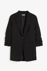 Blazer negro de corte recto con solapas de muesca finas y cierre de un botón. Modelo de corte relajado con bolsillos delanteros ribeteados y mangas tres cuartos recogidas.
