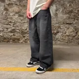 Jean super baggy de denim color gris oscuro con efecto lavado y bordado en el bolsillo trasero.