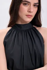 Vestido corto negro con cuello halter y falda con volados.