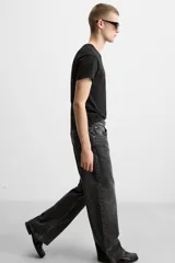 Pantalón de jean celeste con efecto lavado, corte flare fit y caída baggy desde la rodilla hasta el tobillo. Tiene cinco bolsillos y cierre frontal con botones.