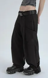 Pantalón negro de corte ancho y tiro alto, con múltiples bolsillos cargo y ajuste en los tobillos. Se lleva con un cinturón negro con hebilla metálica.