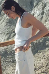 Musculosa blanca de punto acanalado, corte entallado, con escote redondo tanto en la parte delantera como en la trasera.