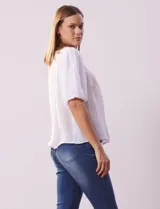 Blusa celeste de gasa marca Zac & Rachel, con cuello redondo, frunces en el frente, mangas 3/4 con puño, abertura central en la espalda y botón.