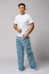Pantalón jean celeste de corte amplio, estilo cargo, con bolsillos laterales con fuelle y solapa.
