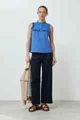 Top celeste sin mangas con cuello con volados y broderie.