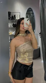 Top strapless color dorado con textura brillante, detalle de choker al cuello y corte asimétrico.