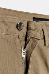 Pantalón chino cropped de tiro alto, color beige, con bolsillos laterales y traseros. Cierre frontal con cremallera y botón.