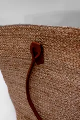 Bolso tipo shopper de yute color beige con asas de cuero marrón.