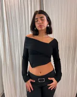 Pantalón negro de tiro bajo con corte acampanado y hebilla plateada en la cintura.