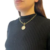 Collar dorado con cadena de eslabones gruesos y dije circular texturizado.